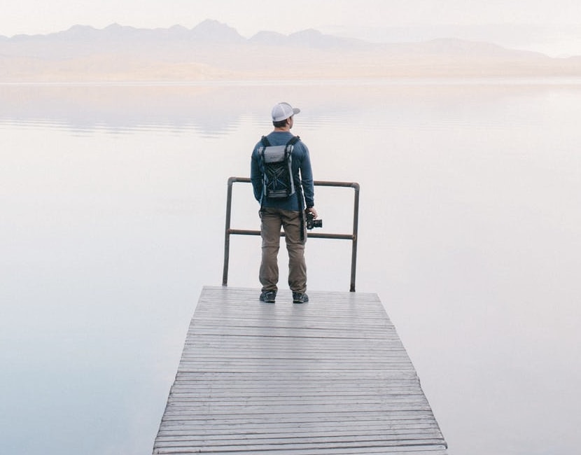 man looking over misty lake