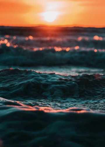 picture of a sunset behind waves